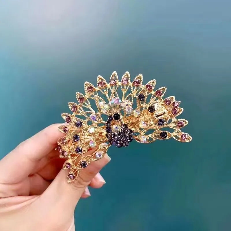 Barette dans une main , strass en forme de paon, barette animal, scintillante
