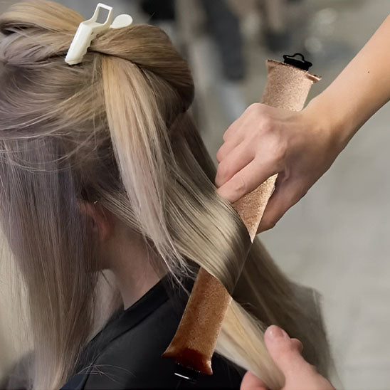 Femme avec bigoudi fait des boucles de cheveux sans chaleur pour créer des boucles parfaites sans abîmer les cheveux. Ces bigoudis innovants permettent de réaliser des coiffures bouclées facilement, tout en préservant la santé des cheveux. Idéals pour un usage quotidien, ils conviennent à tous les types de cheveux et offrent une méthode douce et naturelle pour des boucles durables sans abimer les cheveux .