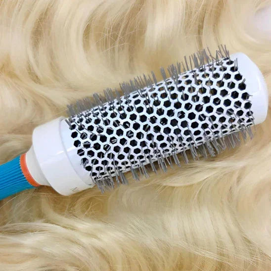 Brosse à brushing professionnelle ronde avec picots métalliques sur cheveux blonds