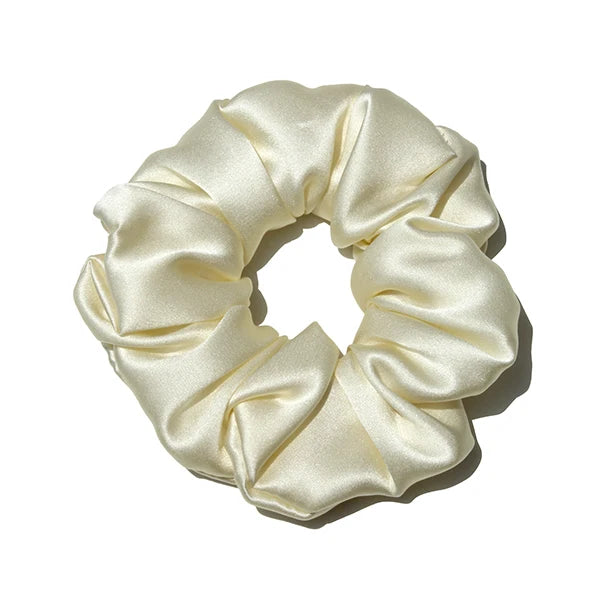 Chouchou en soie ivoire, élégant et doux au toucher, avec finition satinée, idéal pour préserver les cheveux tout en ajoutant une touche chic et raffinée à votre coiffure