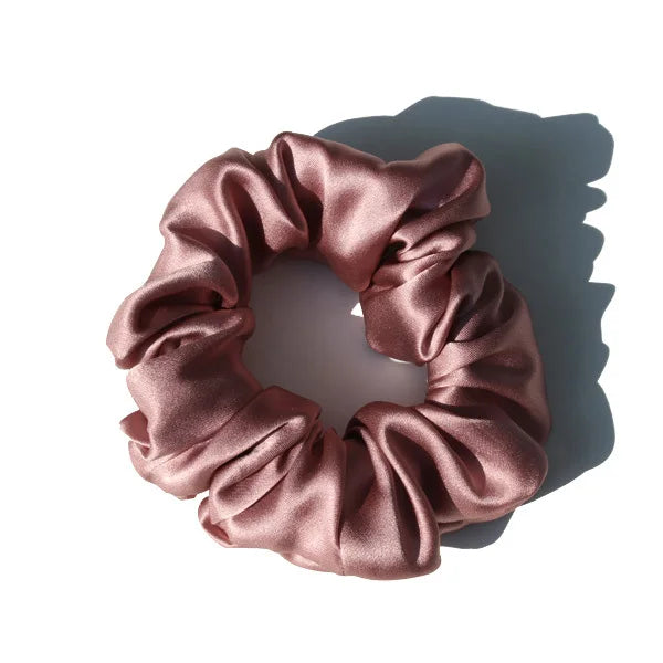 Chouchou en soie rose pastel, élégant et doux au toucher, avec finition satinée, idéal pour préserver les cheveux tout en ajoutant une touche chic et raffinée à votre coiffure