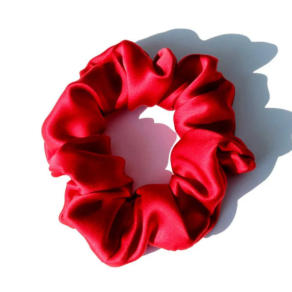 Chouchou en soie rouge, élégant et doux au toucher, avec finition satinée, idéal pour préserver les cheveux tout en ajoutant une touche chic et raffinée à votre coiffure