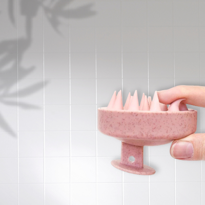 Brosse rose à cheveux démêlante avec picots massants, conçue pour le cuir chevelu.