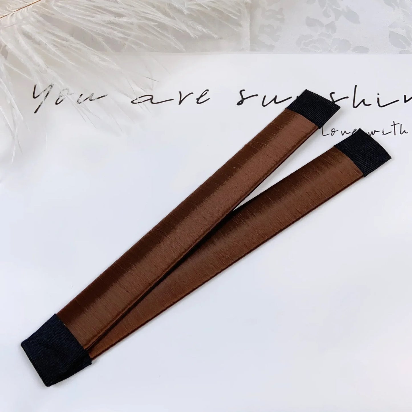 Deux accessoires marrons  à cheveux pour chignon, conçu pour un maintien ferme et une tenue longue durée. 