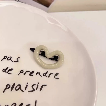 Barrette blanche en forme de cœur, élégante et mignonne, idéale comme accessoire pour les cheveux avec une touche de douceur. 
