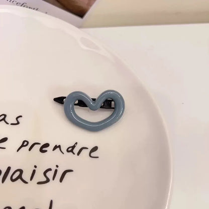 Barrette grise en forme de cœur, élégante et mignonne, idéale comme accessoire pour les cheveux avec une touche de douceur. 