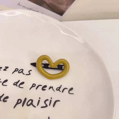 Barrette jaune en forme de cœur, élégante et mignonne, idéale comme accessoire pour les cheveux avec une touche de douceur. 
