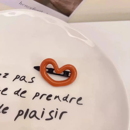 Barrette orange en forme de cœur, élégante et mignonne, idéale comme accessoire pour les cheveux avec une touche de douceur. 