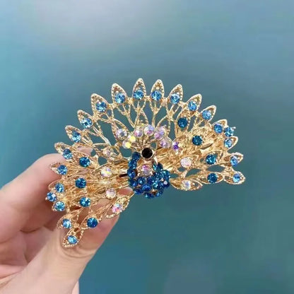 Barette dans une main , strass en forme de paon, barette animal, scintillante, bleu