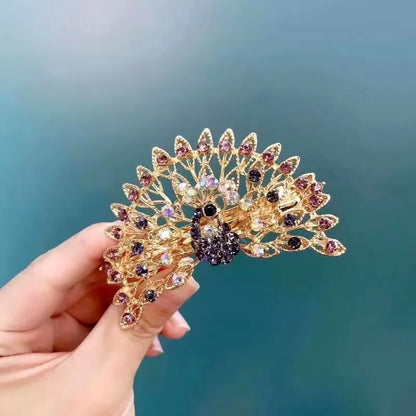 Barette dans une main , strass en forme de paon, barette animal, scintillante