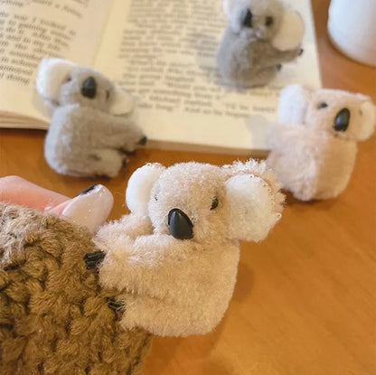Pinces à cheveux peluche Koala  grise ou beige présentés sur un bureau  : l'accessoire mignon et pratique - Parfaite pour les petites filles comme pour les adultes, cette pince originale et kawaii permet de maintenir vos cheveux tout en apportant une note ludique et mignonne-
