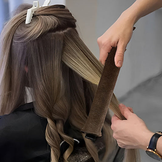 Femme  avec belles boucles utilise  bigoudi marron sans chaleur pour créer des boucles parfaites sans abîmer les cheveux. Ces bigoudis innovants permettent de réaliser des coiffures bouclées facilement, tout en préservant la santé des cheveux. Idéals pour un usage quotidien, ils conviennent à tous les types de cheveux et offrent une méthode douce et naturelle pour des boucles durables sans abimer les cheveux . 