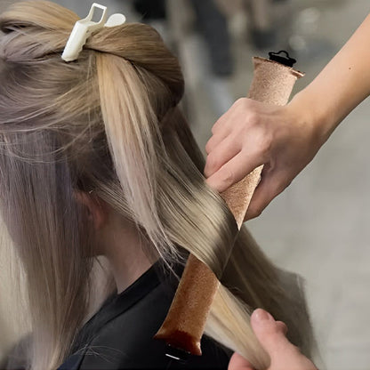 Femme avec bigoudi fait des boucles de cheveux sans chaleur pour créer des boucles parfaites sans abîmer les cheveux. Ces bigoudis innovants permettent de réaliser des coiffures bouclées facilement, tout en préservant la santé des cheveux. Idéals pour un usage quotidien, ils conviennent à tous les types de cheveux et offrent une méthode douce et naturelle pour des boucles durables sans abimer les cheveux . 