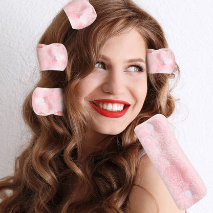 Femme souriante avec un lot de bigoudis roses pour mise en plis des cheveux à la maison