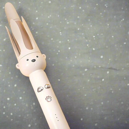 Boucleur ourson beige posé sur fond scintillant, design mignon et sécurisé pour enfants