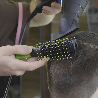 un coiffeur utilise la brosse noire et verte  antistatique pour cheveux avec un sèche cheveu– Démêlage efficace et en douceur