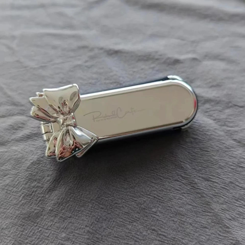 Brosse à cheveux pliable compacte avec miroir intégré, un accessoire élégant et pratique pour des retouches rapides où que vous soyez. Son design argenté chic ajoute une touche de raffinement à votre routine beauté. Idéale pour glisser dans un sac à main ou une trousse de voyage . 