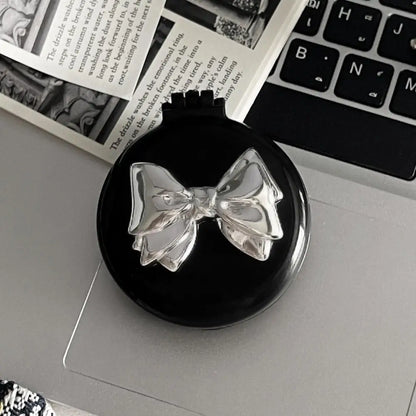 Brosse à cheveux ronde et pliable noir et argentée , alliant élégance et la praticité. Dotée d'un miroir intégré, elle est parfaite pour des retouches beauté à tout moment. Son design chic en fait un accessoire indispensable pour les déplacements, voyages. 