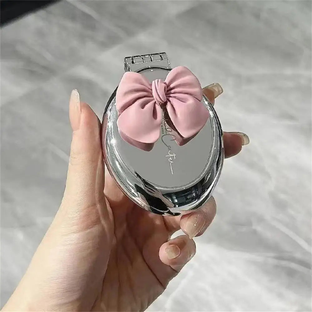 Brosse à cheveux ronde argenté avec nœud rose et pliable, alliant élégance et la praticité. Dotée d'un miroir intégré, elle est parfaite pour des retouches beauté à tout moment. Son design chic en fait un accessoire indispensable pour les déplacements, voyages. 
