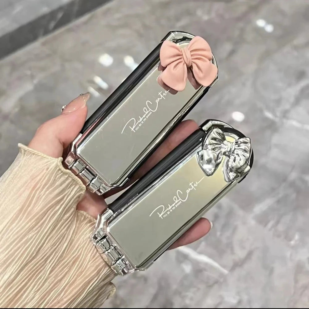 Brosse à cheveux pliable compacte avec miroir intégré avec nœud rose ou argent&, un accessoire élégant et pratique pour des retouches rapides où que vous soyez. Son design argenté chic ajoute une touche de raffinement à votre routine beauté. Idéale pour glisser dans un sac à main ou une trousse de voyage . 