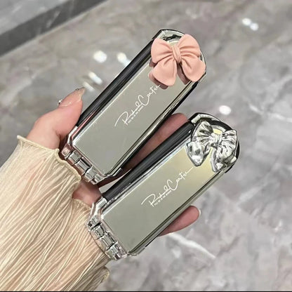 Brosse à cheveux pliable compacte avec miroir intégré avec nœud rose ou argent&, un accessoire élégant et pratique pour des retouches rapides où que vous soyez. Son design argenté chic ajoute une touche de raffinement à votre routine beauté. Idéale pour glisser dans un sac à main ou une trousse de voyage . 