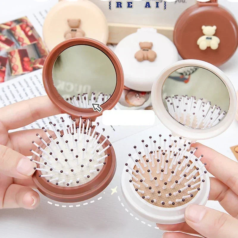 Deux brosses à cheveux pliables ouvertes avec miroir intégré, idéale pour un coiffage pratique et compact en déplacement.