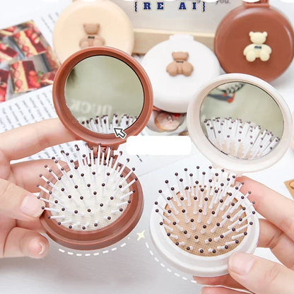 Deux brosses à cheveux pliables ouvertes avec miroir intégré, idéale pour un coiffage pratique et compact en déplacement.