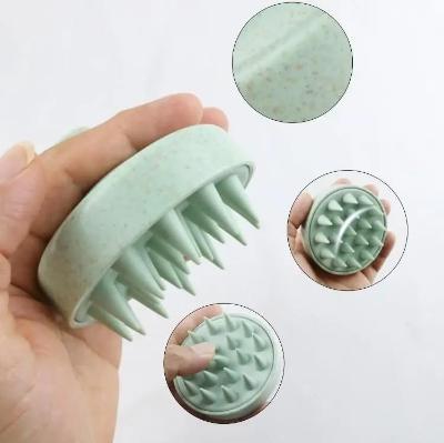 Brosse massage cuir chevelu ergonomique verte avec picots massants, conçue pour les cheveux  et stimuler la circulation sanguine du cuir chevelu. 