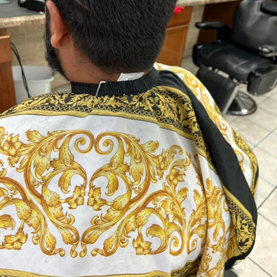 Cape de coupe pour coiffeur, décorée d'un motif de lion, conçue pour faciliter la coupe de cheveux tout en protégeant les vêtements