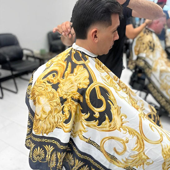 Cape de coupe pour coiffeur, décorée d'un motif de lion, pratique pour faciliter la coupe de cheveux tout en protégeant les vêtements