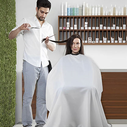 Grande cape de coupe blanche professionnelle, conçue pour offrir une protection optimale et un confort maximal. Imperméable, antistatique et ajustable grâce à sa fermeture pratique, elle est idéale pour les salons de coiffure comme pour une utilisation à domicile. Son tissu léger et résistant assure une expérience agréable pour le client tout en facilitant le coiffeur. 