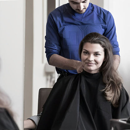 Cape noire ajustée, de coupe cheveux professionnelle, conçue pour offrir une protection optimale et un confort maximal. Imperméable, antistatique et ajustable grâce à sa fermeture pratique, elle est idéale pour les salons de coiffure comme pour une utilisation à domicile. Son tissu léger et résistant assure une expérience agréable pour le client tout en facilitant le coiffeur. 