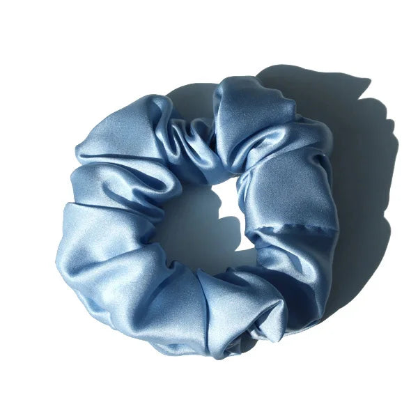 Chouchou en soie bleu, élégant et doux au toucher, avec finition satinée, idéal pour préserver les cheveux tout en ajoutant une touche chic et raffinée à votre coiffure