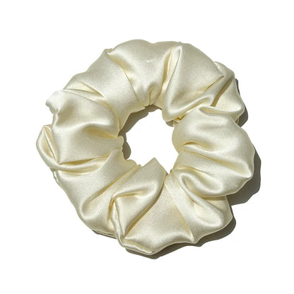 Chouchou en soie ivoire, élégant et doux au toucher, avec finition satinée, idéal pour préserver les cheveux tout en ajoutant une touche chic et raffinée à votre coiffure