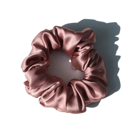 Chouchou en soie rose pastel, élégant et doux au toucher, avec finition satinée, idéal pour préserver les cheveux tout en ajoutant une touche chic et raffinée à votre coiffure