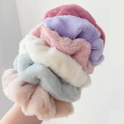 Chouchous en fausse fourrure de couleur pastel, présentation de la douceur sur bras humain du produit.
