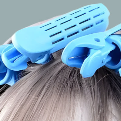 Zoom Utilisation d'un clip volumateur bleu clair pour donner du volume aux racines sans chaleur