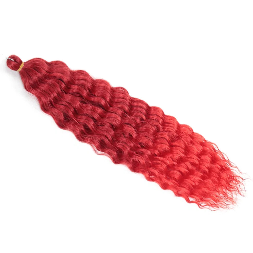 Mèche de cheveux ondulée rouge foncé avec dégradé vers un rouge plus clair, attachée par un élastique jaune, posée sur fond blanc.

