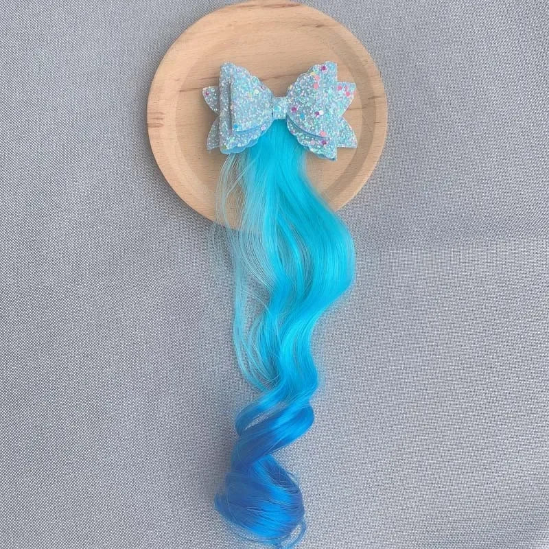 Extension de cheveux avec barrette en forme de nœud bleu, ajoutant une touche douce et féminine à la coiffure
