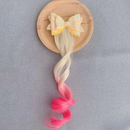 Extension de cheveux avec barrette en forme de nœud jaune et rose, ajoutant une touche douce et féminine à la coiffure