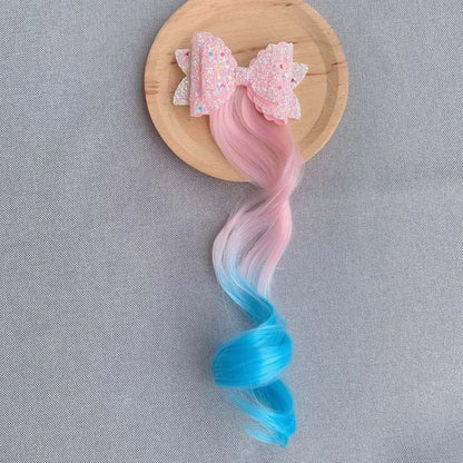 Extension de cheveux avec barrette en forme de nœud rose clair et bleu, ajoutant une touche douce et féminine à la coiffure