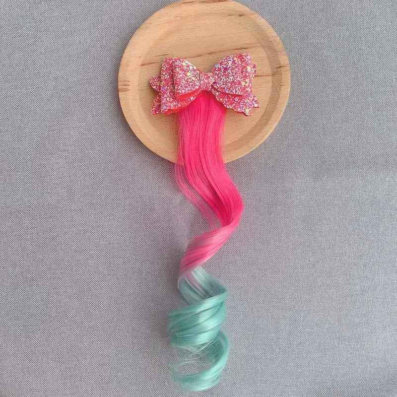 Extension de cheveux avec barrette en forme de nœud rose et vert, ajoutant une touche douce et féminine à la coiffure