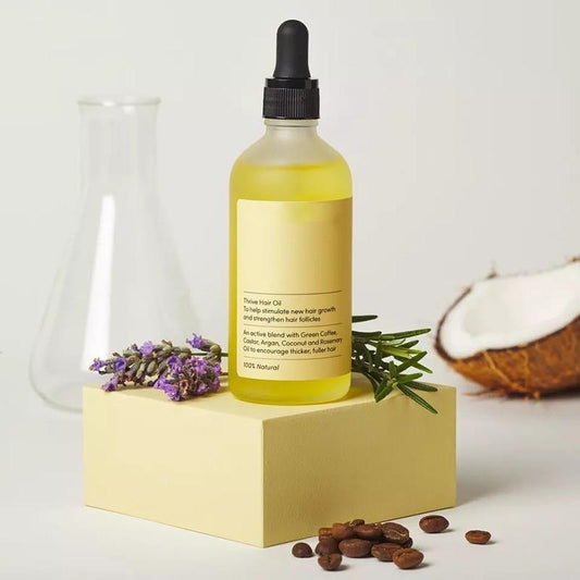 Flacon d'huile capillaire naturelle Floréna pour la repousse des cheveux, à base d’huiles végétales, présenté dans un décor doux et apaisant.