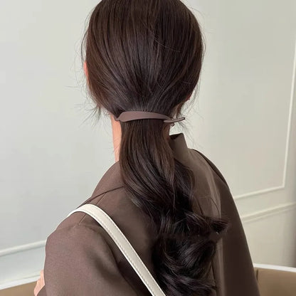 femme professionnelle portant une pince à cheveux élégante, conçue pour maintenir les cheveux en place avec style et confort, idéale pour un usage quotidien ou pour des coiffures spéciales.