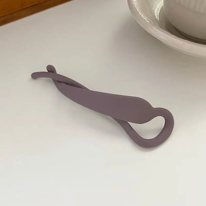 Pince à cheveux en plastique, de taille moyenne, conçue pour maintenir les cheveux en place de manière pratique et sécurisée, avec un design simple et fonctionnel.