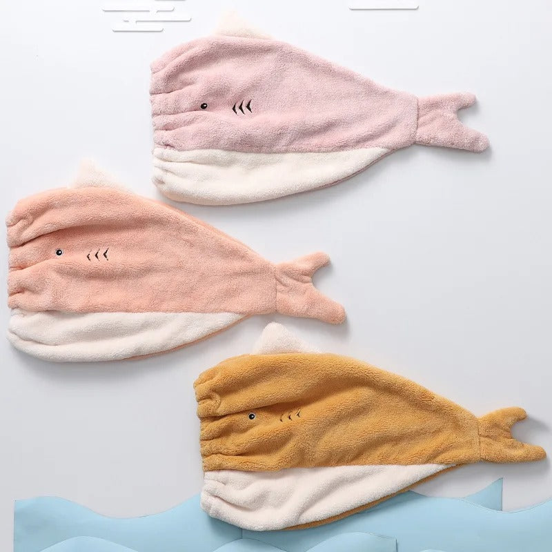 Trois bonnets en serviette en forme de requins  qui nagent. 